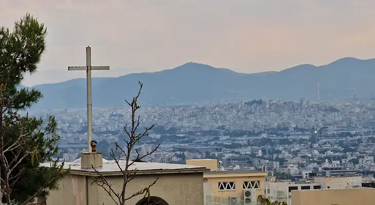 Hustak i Aten. Ett kors syns i förgrunden.